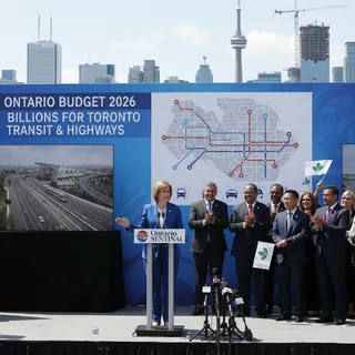 A busy Toronto street with construction signs and transit infrastructure visible in front of provincial buildings.